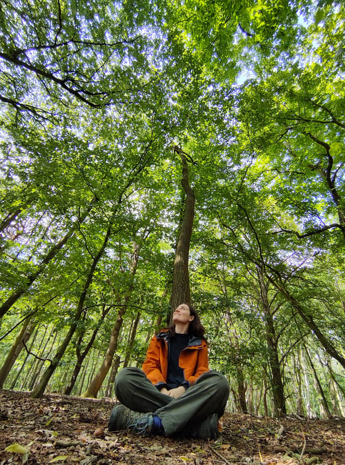 Photo of Kitty Stephenson sat leaning against a tree, Forest Bathing. Photo of Kitty Stephenson sat leaning against a tree, Forest Bathing.